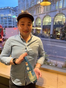 Individual photo of member attending the BSA Study Group at Vagabond Monument and holding bottle of Ginjo sake