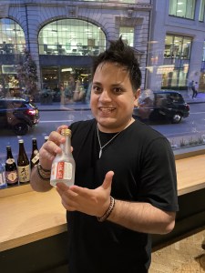 Individual photo of member attending the BSA Study Group at Vagabond Monument and holding bottle of Ginjo sake