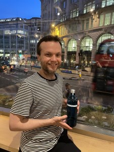 Individual photo of member attending the BSA Study Group at Vagabond Monument and holding bottle of Ginjo sake