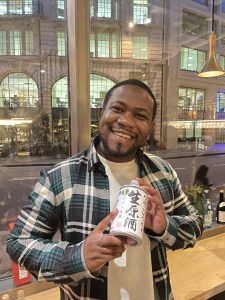 Individual photo of member attending the BSA Study Group at Vagabond Monument and holding bottle of Ginjo sake