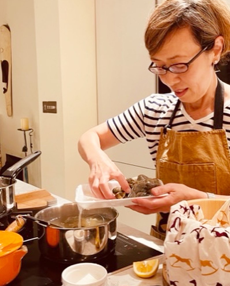 Akemi cooking over a pan of boiling water